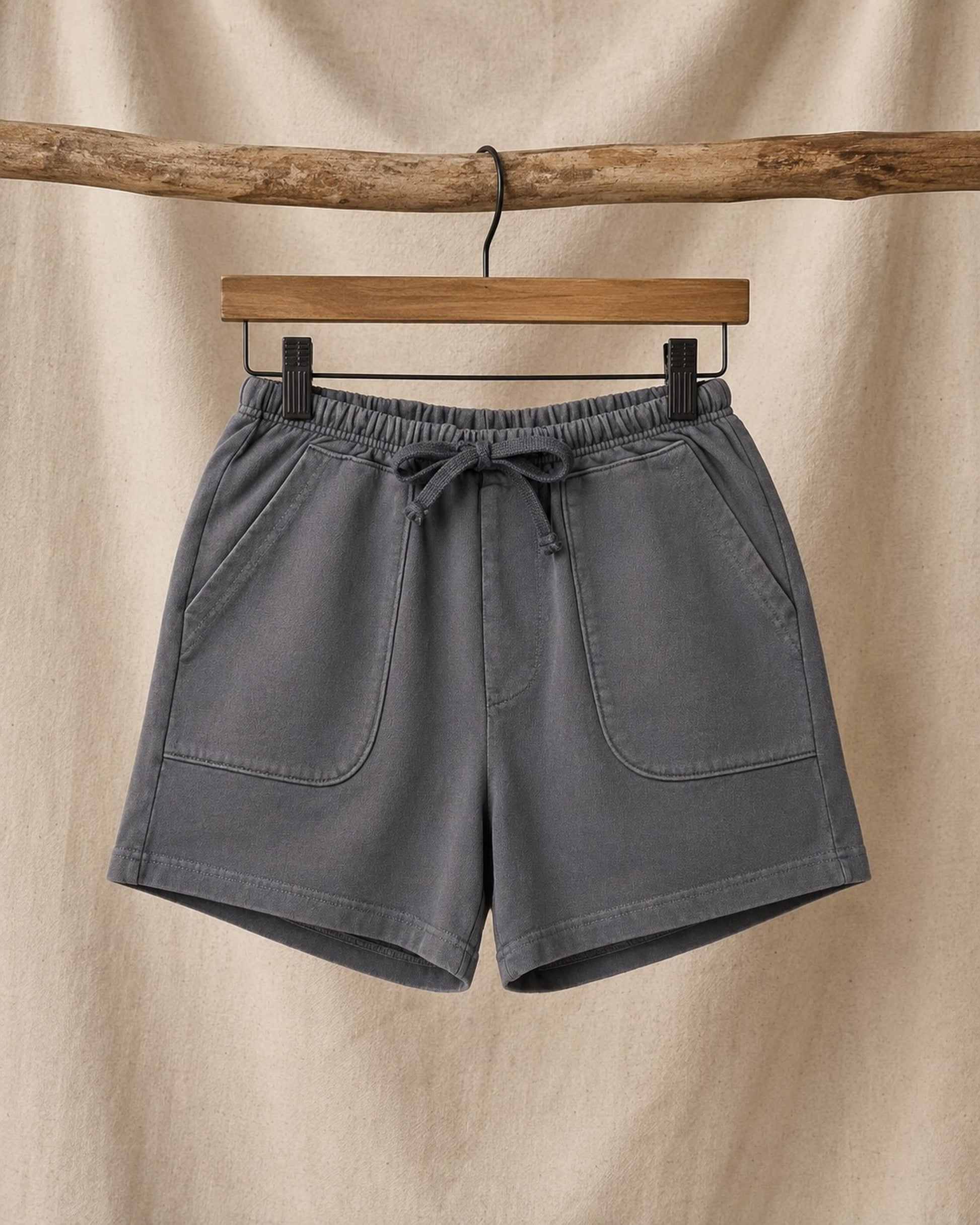 Front of Surfing Cowboys Relaxed Shorts in Loopback Cotton – Dove Grey on hanger in front of canvas background