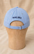 Back view of light blue Surfing Cowboys Rising Sun Cap with navy MALIBU embroidery and adjustable buckle strap.
